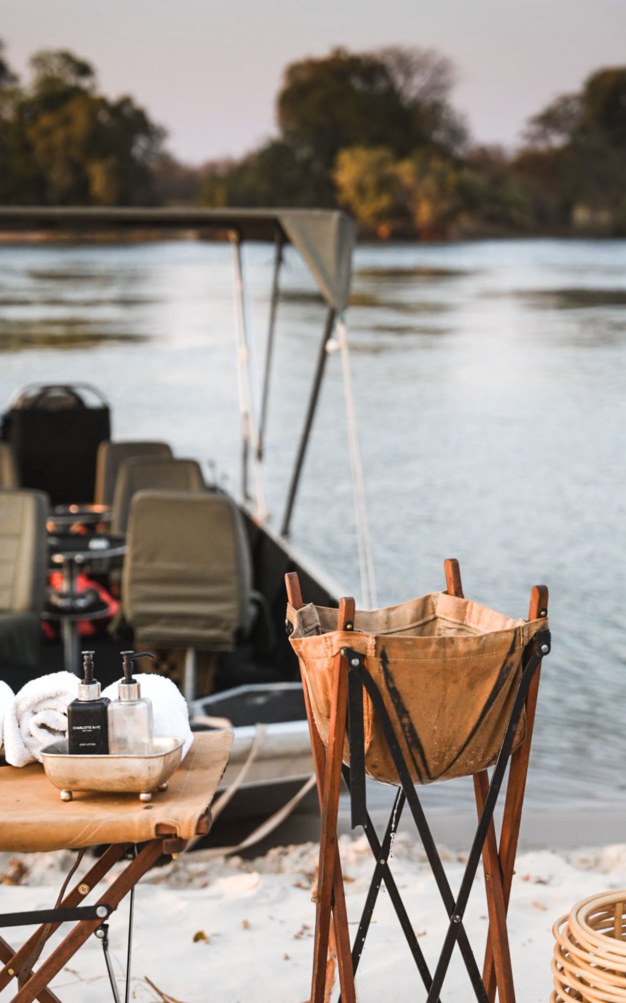 Outdoor dining setup with folding chairs by a lake or waterfront.