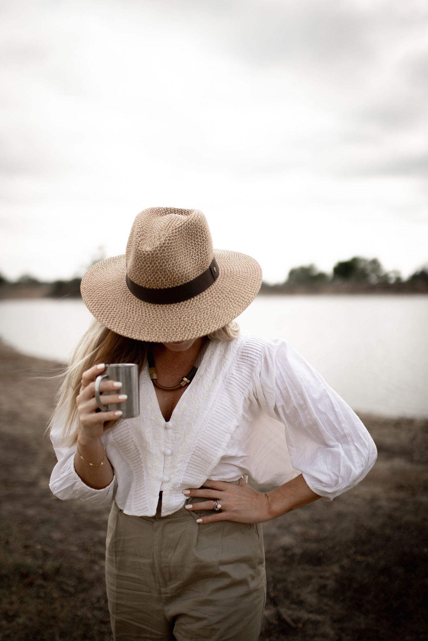 Figure in white blouse and straw hat photographed in monochromatic style.