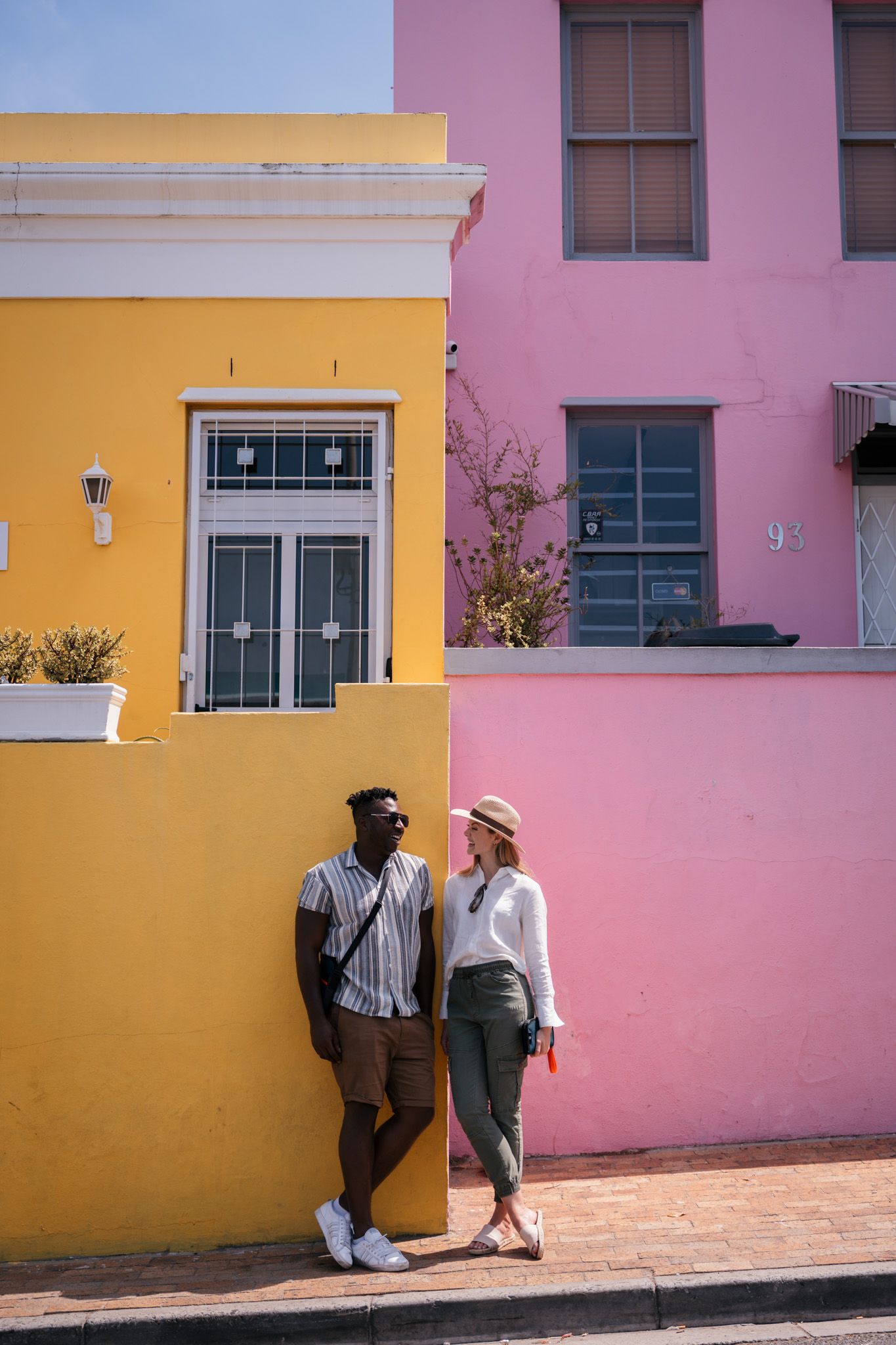 A series of pink and yellow exterior walls feature contrasting architectural elements and shadows.
