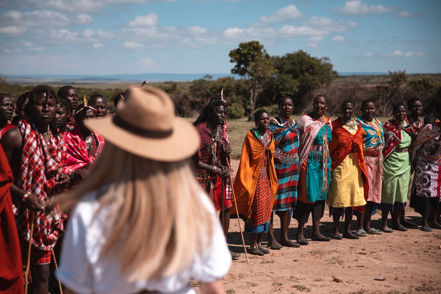 Local Maasai community members in colorful traditional dress gather for a cultural ceremony.