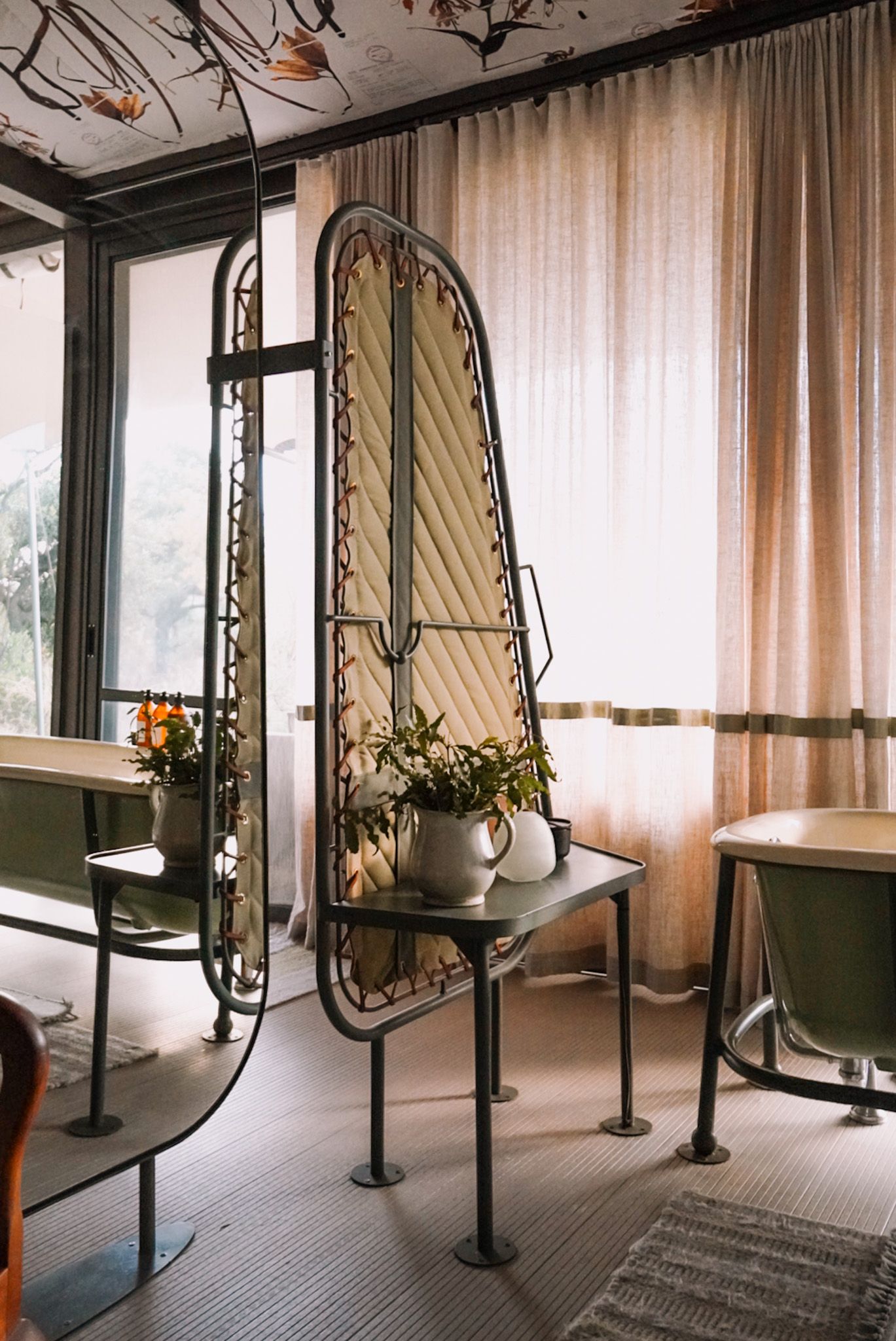 Elegant vanity area with ornate mirrors and natural lighting through sheer curtains.