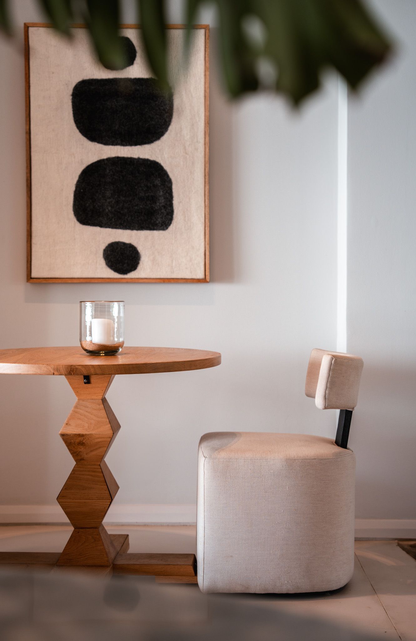 Minimalist dining area with geometric wooden table and abstract wall art.