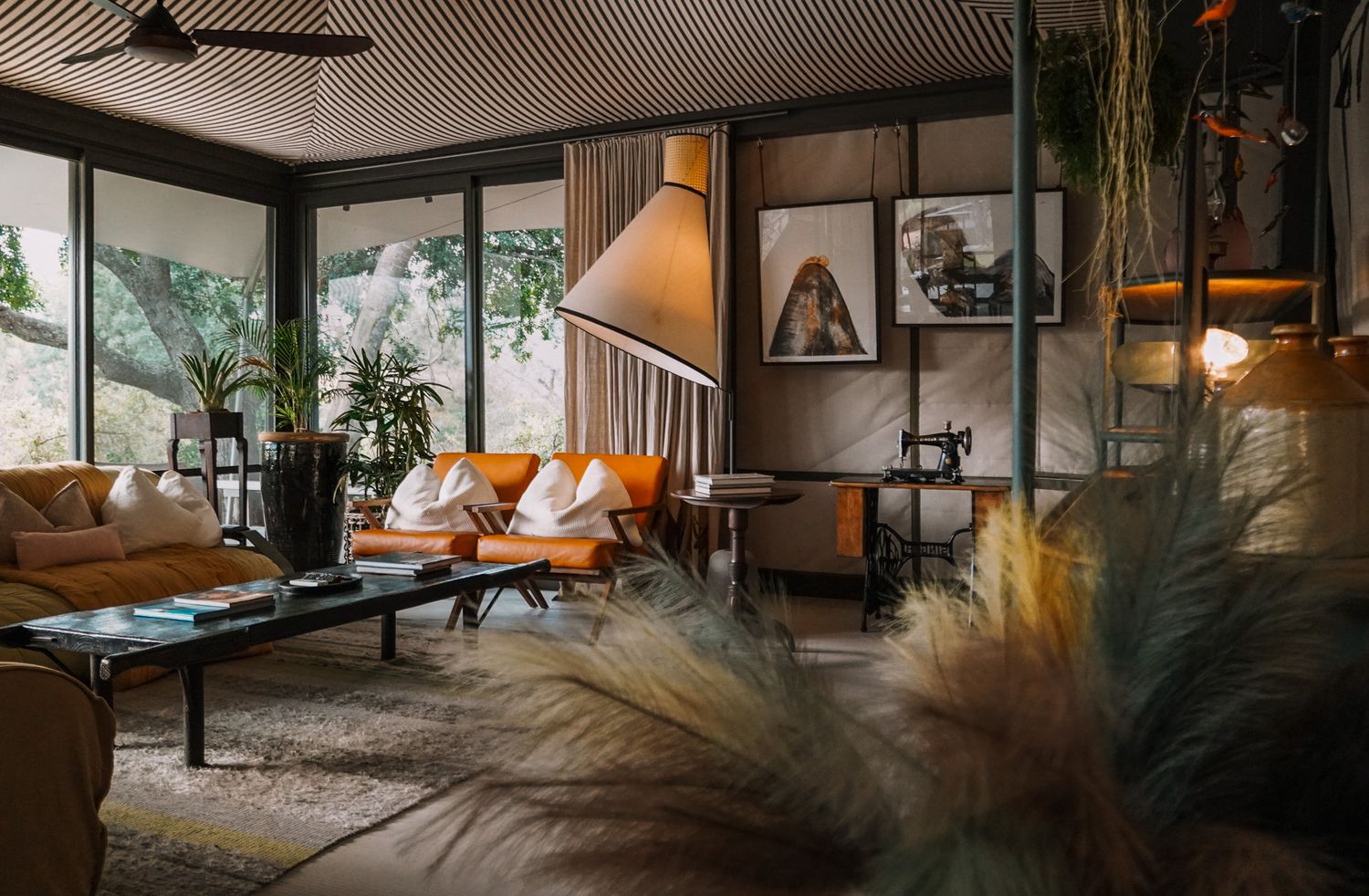 Mid-century modern living room with lush plants and leather furniture in natural light.