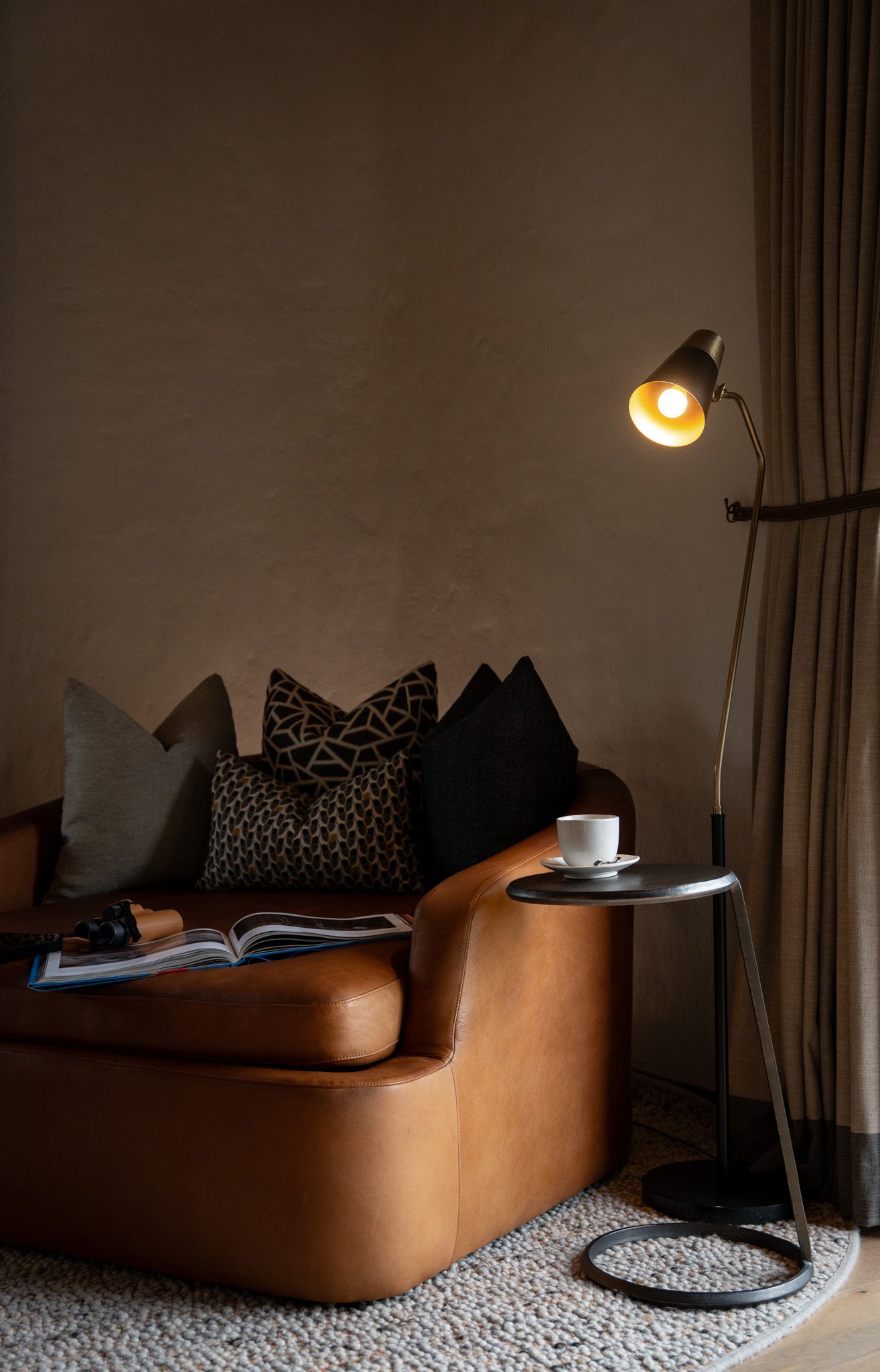 Modern minimalist lounge area with leather seating and ambient lighting creating cozy atmosphere.