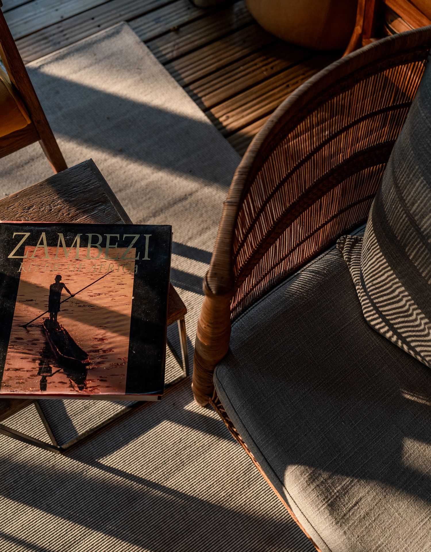 Sunlight casting dramatic shadows on wooden deck chairs and floor.
