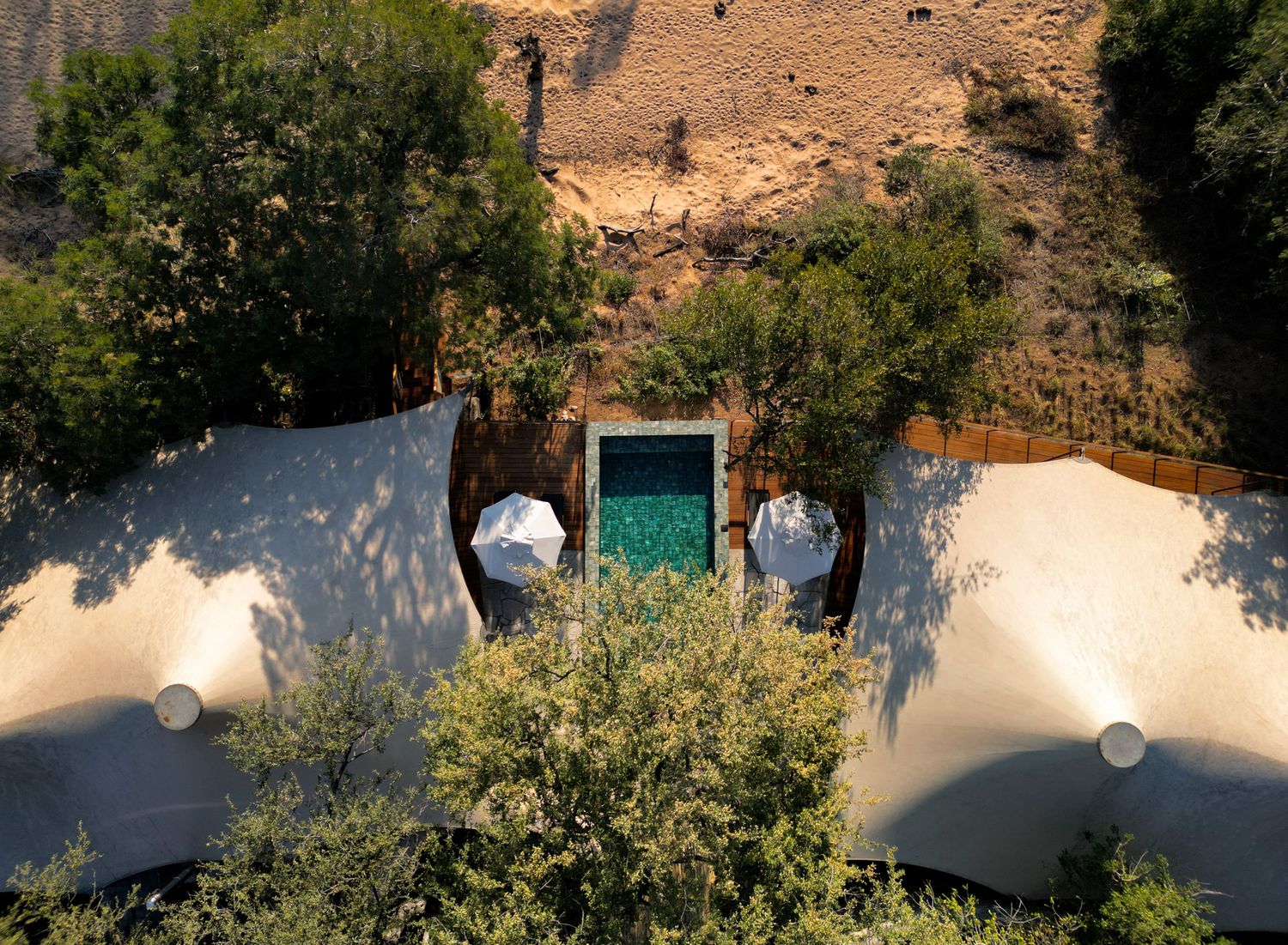 Desert property with modern architecture and swimming pool viewed from above.