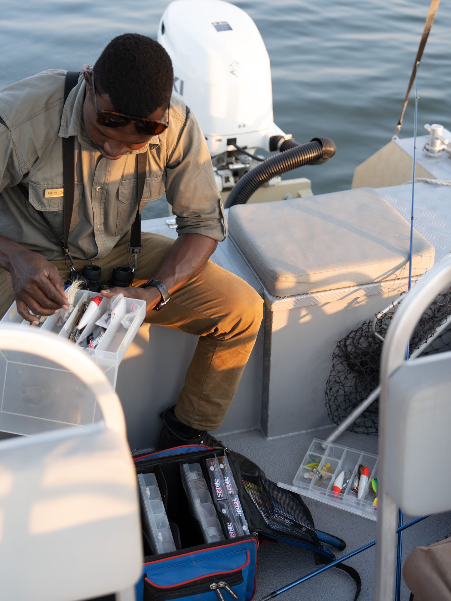 Preparing fishing tackle and equipment on a modern boat deck during daytime.