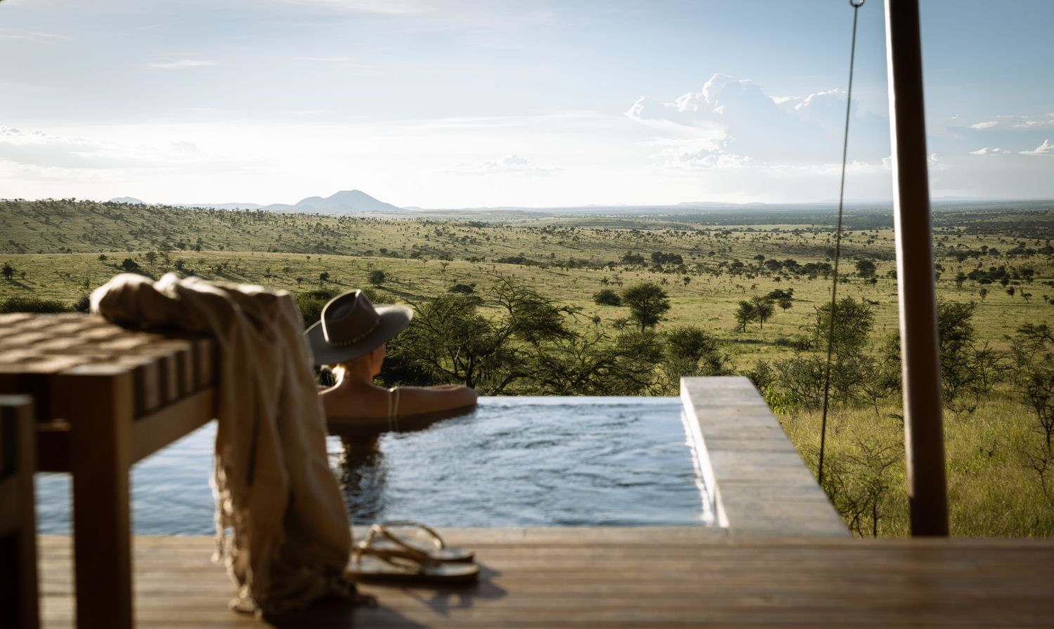 Panoramic view of African savanna landscape from elevated wooden deck.