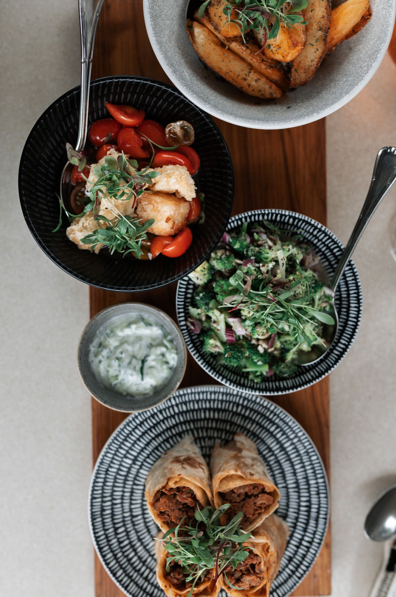Overhead view of beautifully plated dishes with microgreens and colorful garnishes.
