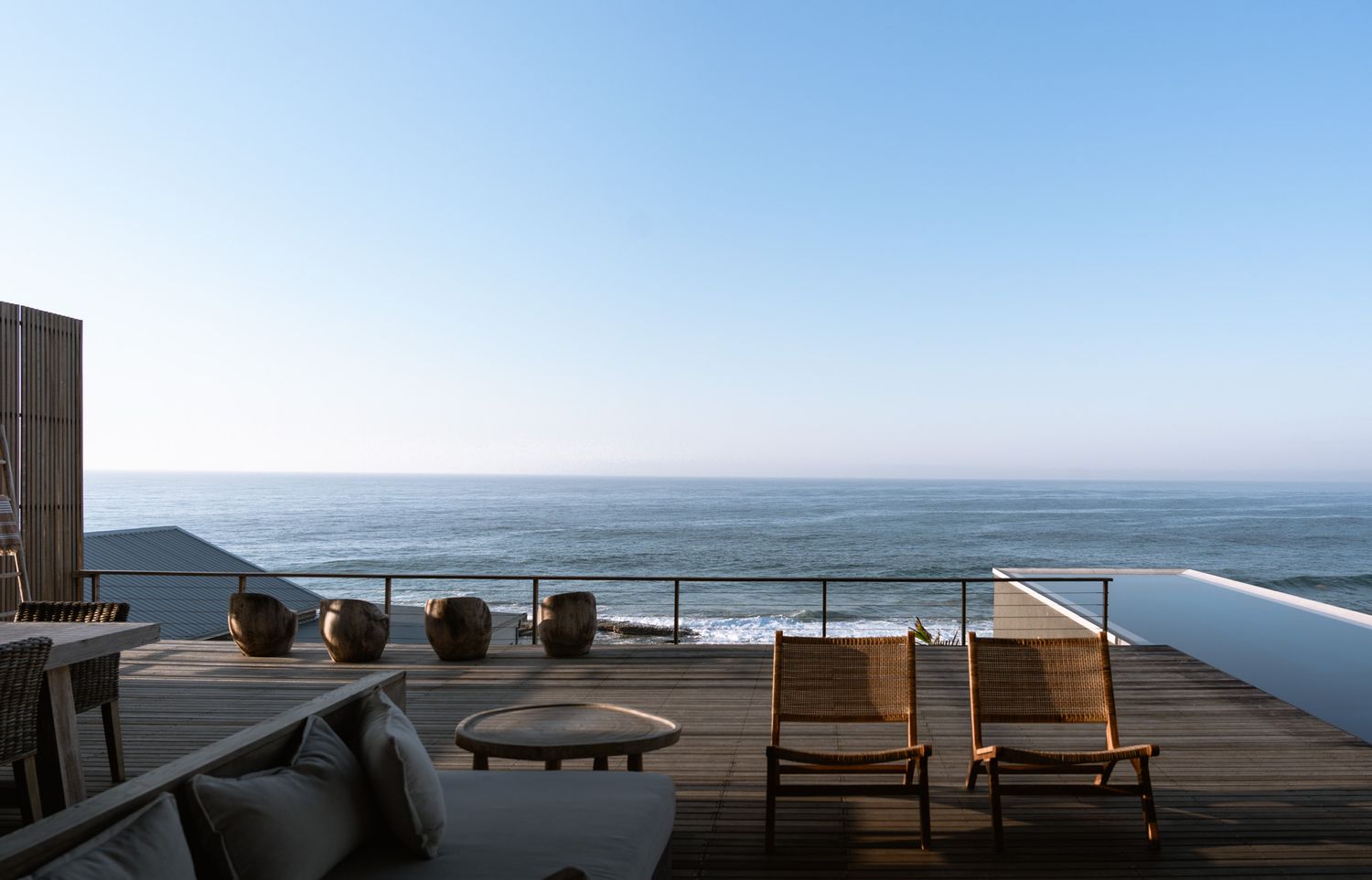 Modern oceanfront terrace with comfortable loungers and panoramic sea views.