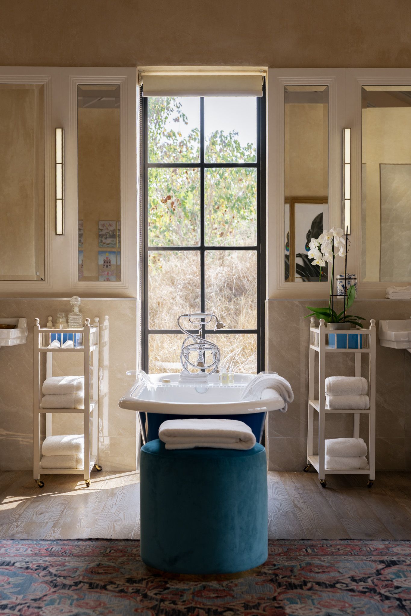 Modern spa bathroom with freestanding tub and large windows overlooking natural surroundings.