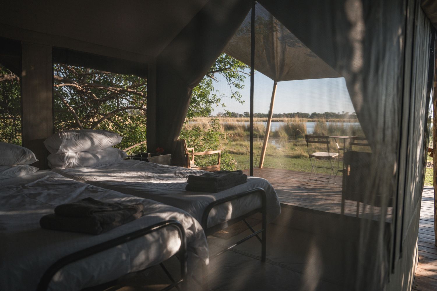 Sun-filled safari lodge interior with comfortable seating and panoramic landscape views.