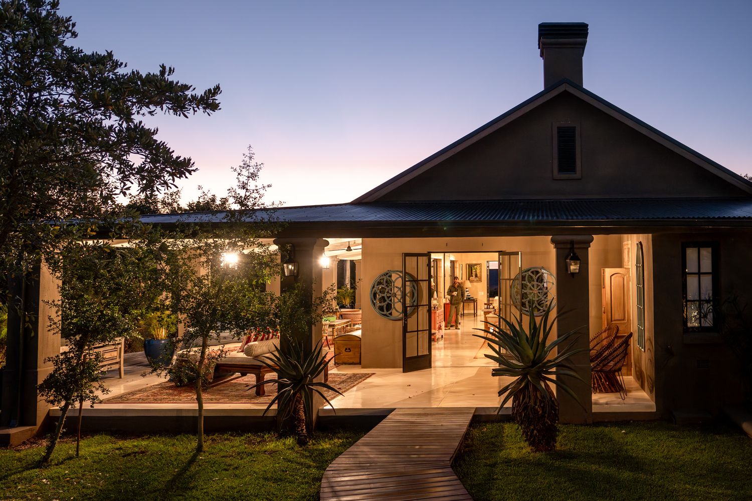Resort buildings illuminated at dusk with pathway lights leading to entrance.