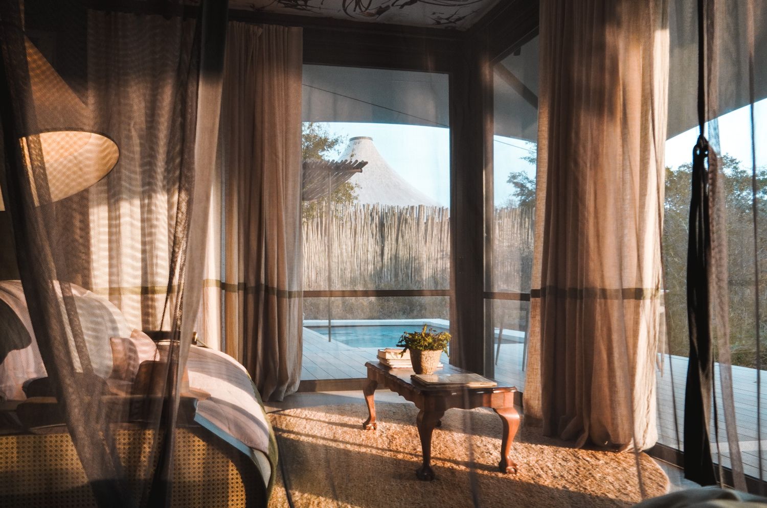 Sheer curtains blowing in the breeze by large windows with natural light.