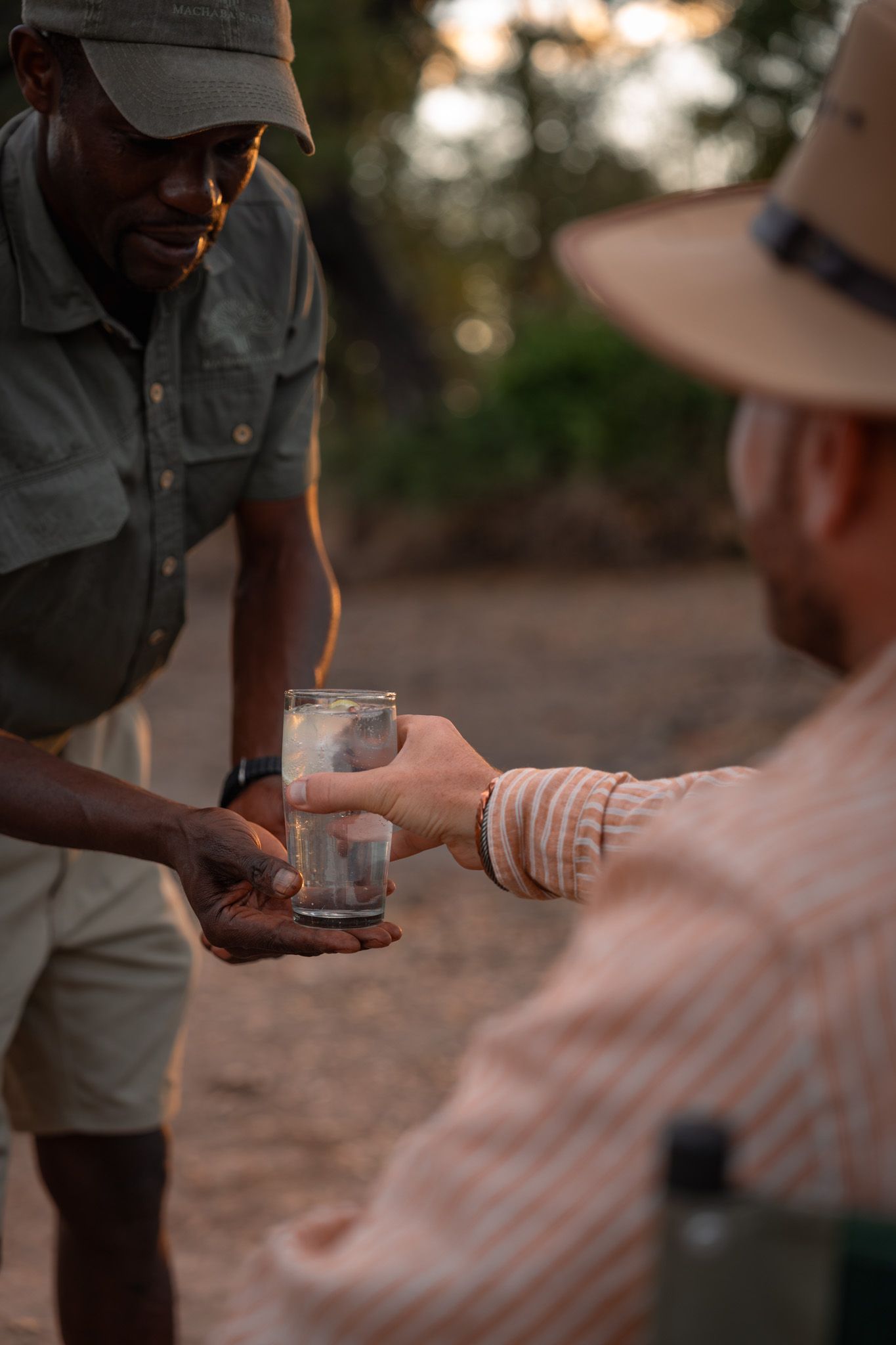 Staff member serving refreshments during sunset safari cocktail hour.