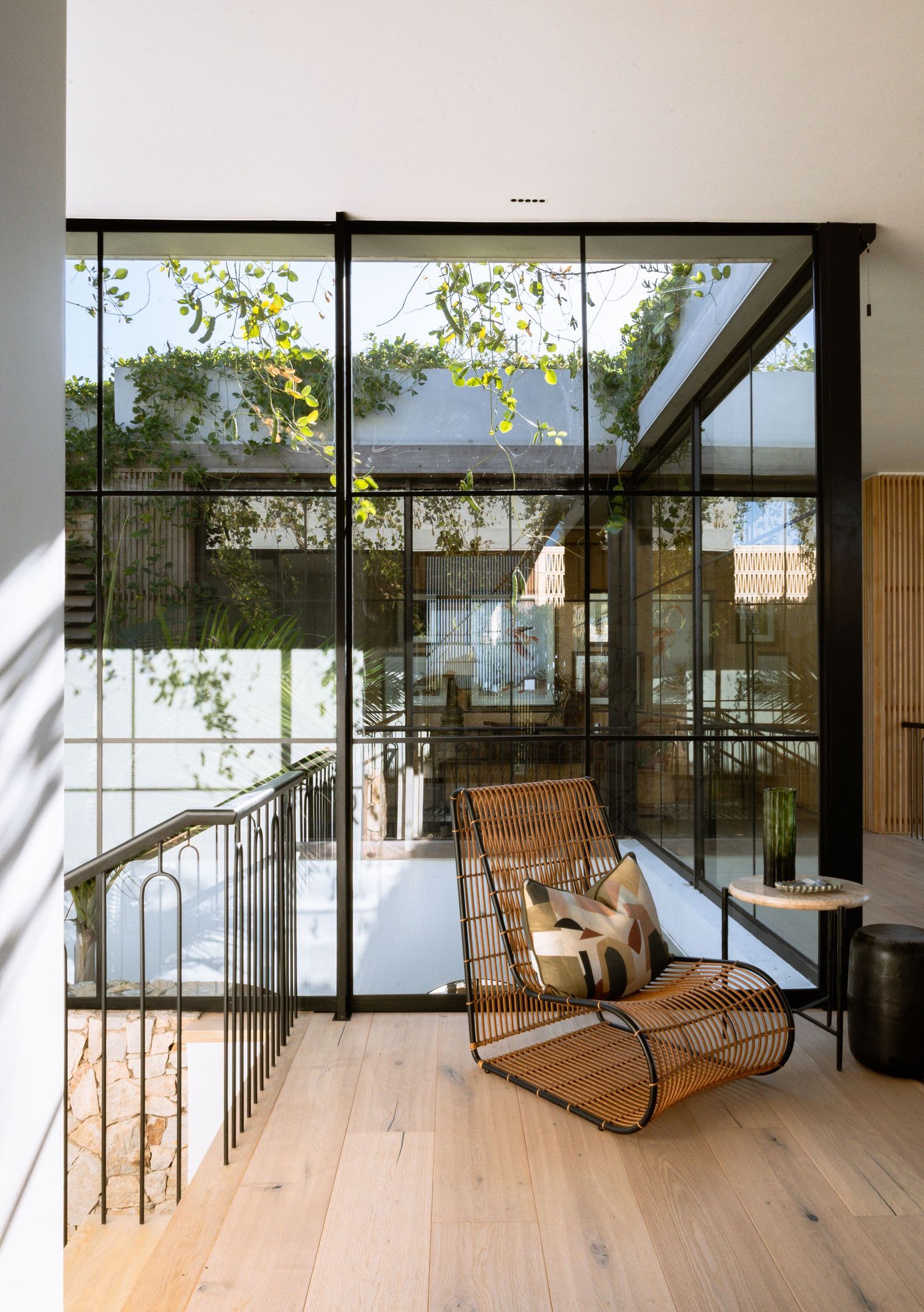 Contemporary living space with floor-to-ceiling windows and natural wood flooring.