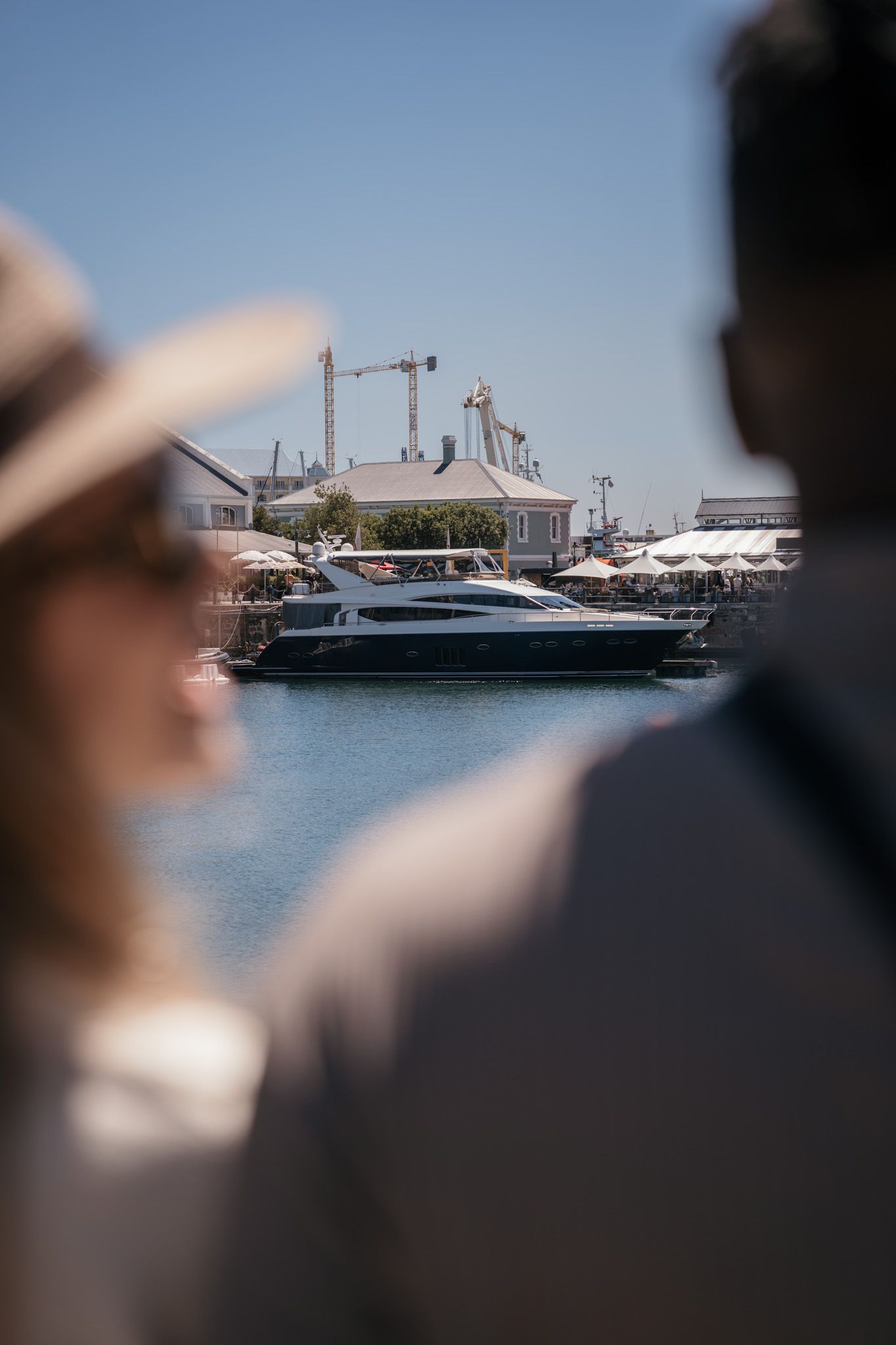 Luxury yachts docked in a marina with clear blue water and sunny skies.