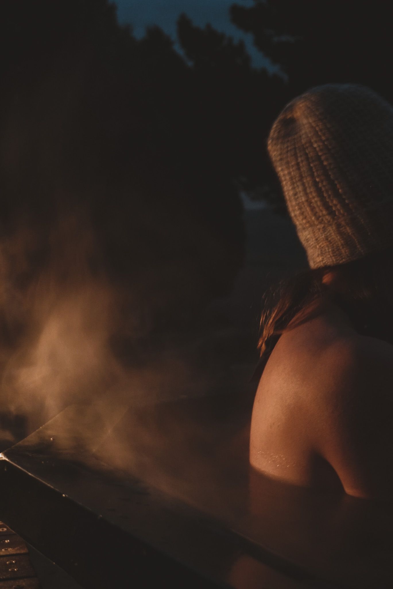 Atmospheric nighttime portrait with steam or smoke creating a moody ambiance.