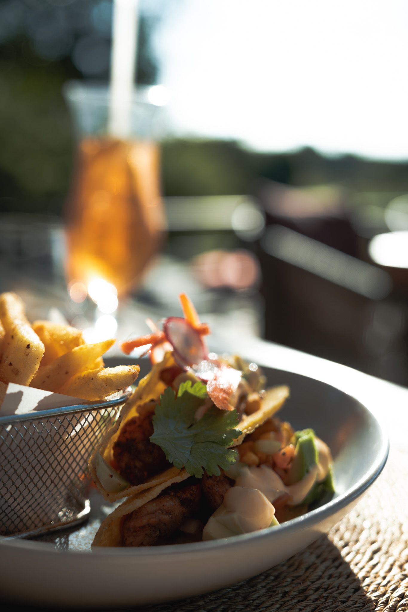 Close-up of elegantly plated dish with garnish in natural sunlight.