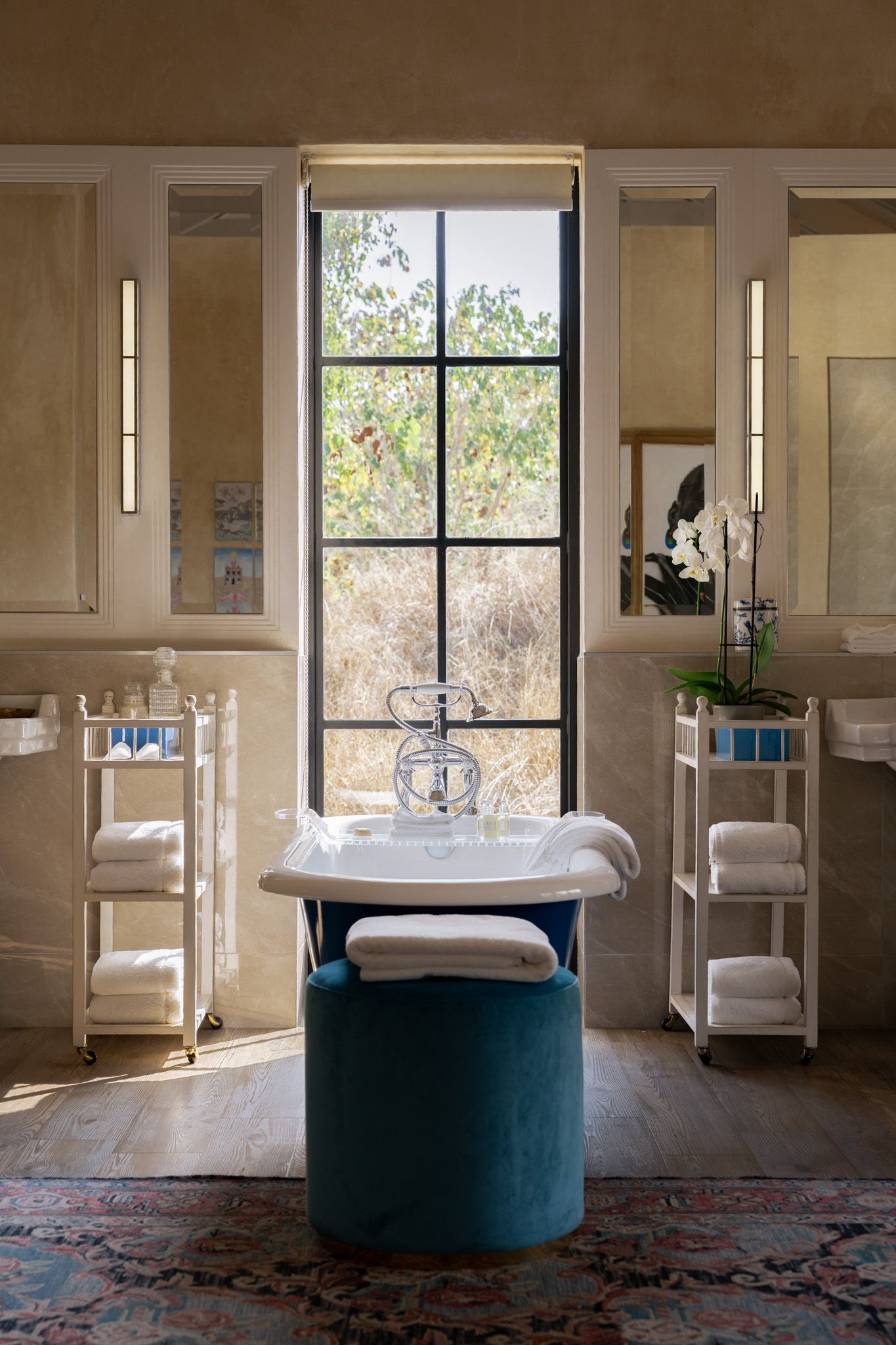 Modern spa bathroom with freestanding tub, large windows, and natural light.