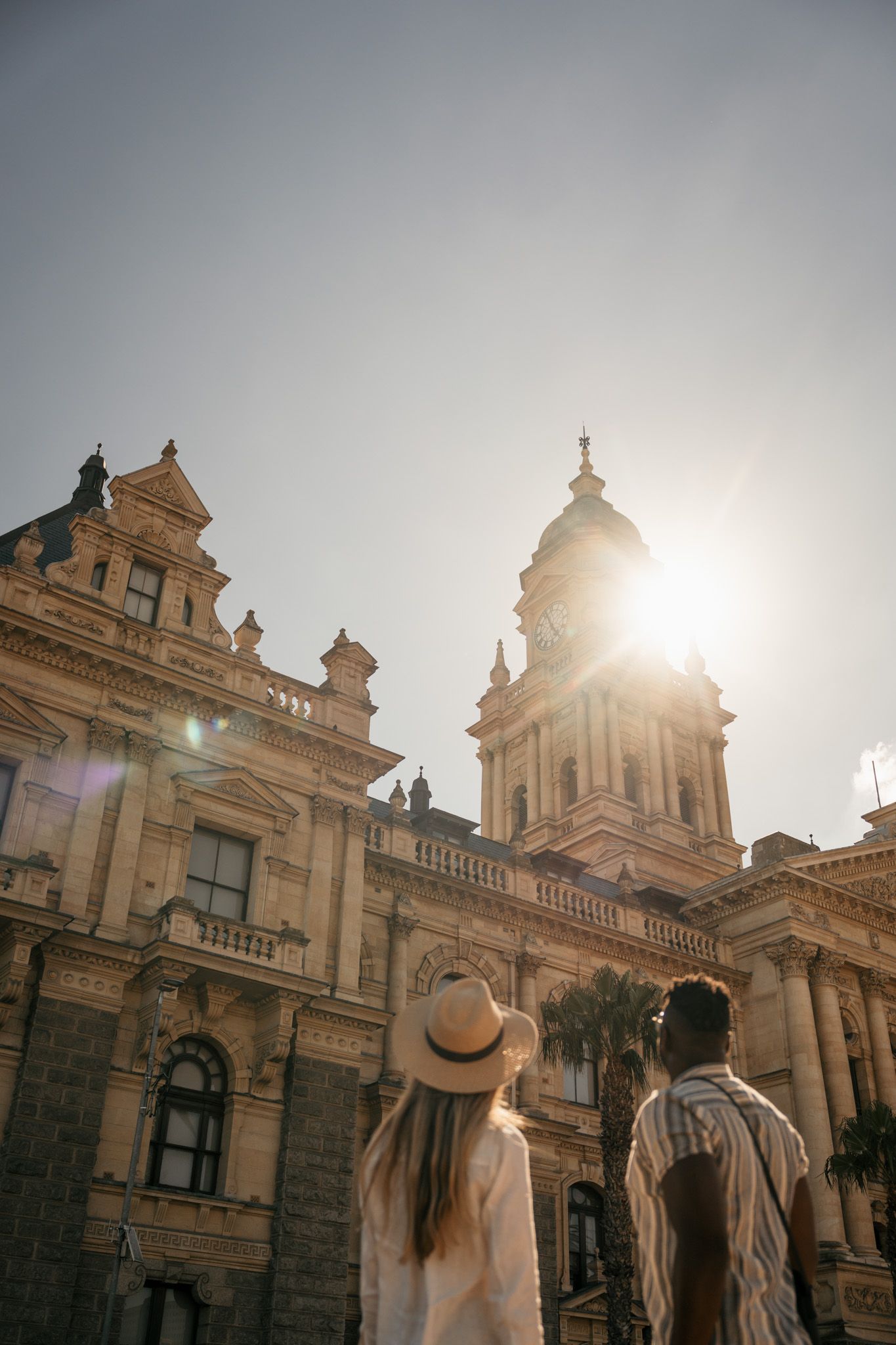 Historic ornate building façade with classical architecture photographed against bright sunlight.