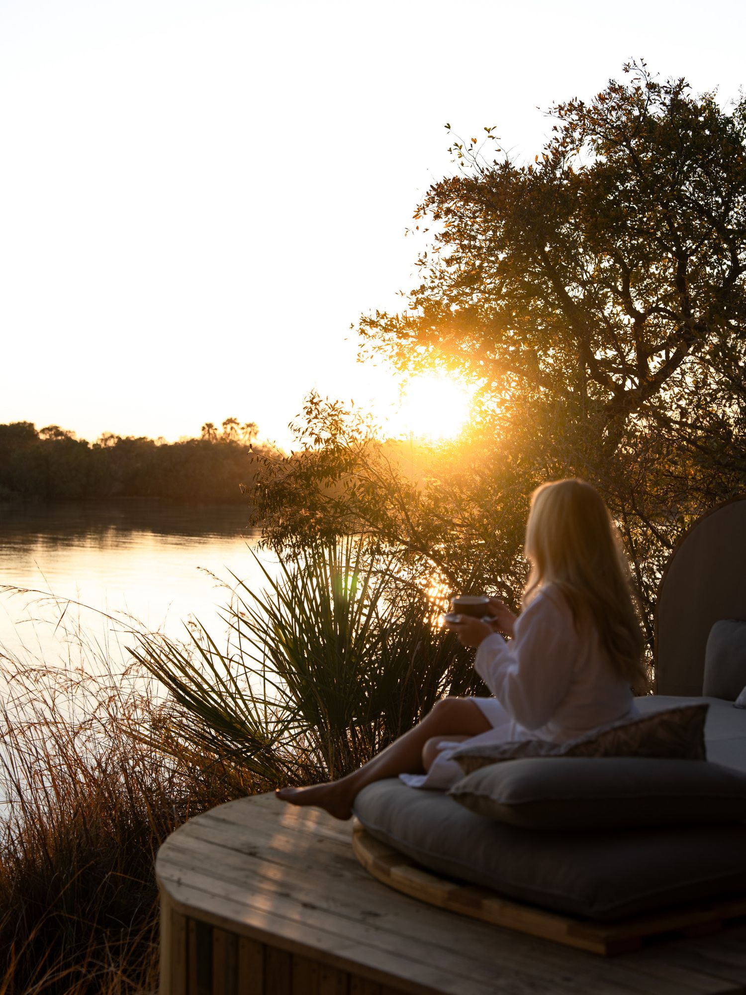 Peaceful sunset lounge area by the waterfront with natural lighting.