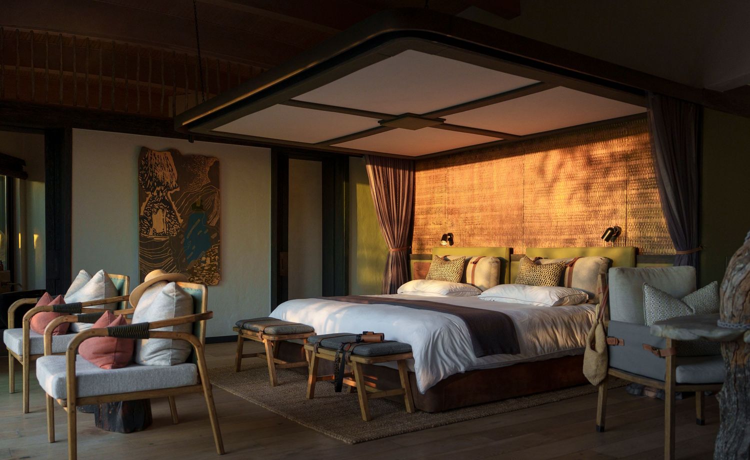 Luxurious safari lodge bedroom with canopy bed, earthy brick walls, ambient lighting, and elegant wooden furniture.