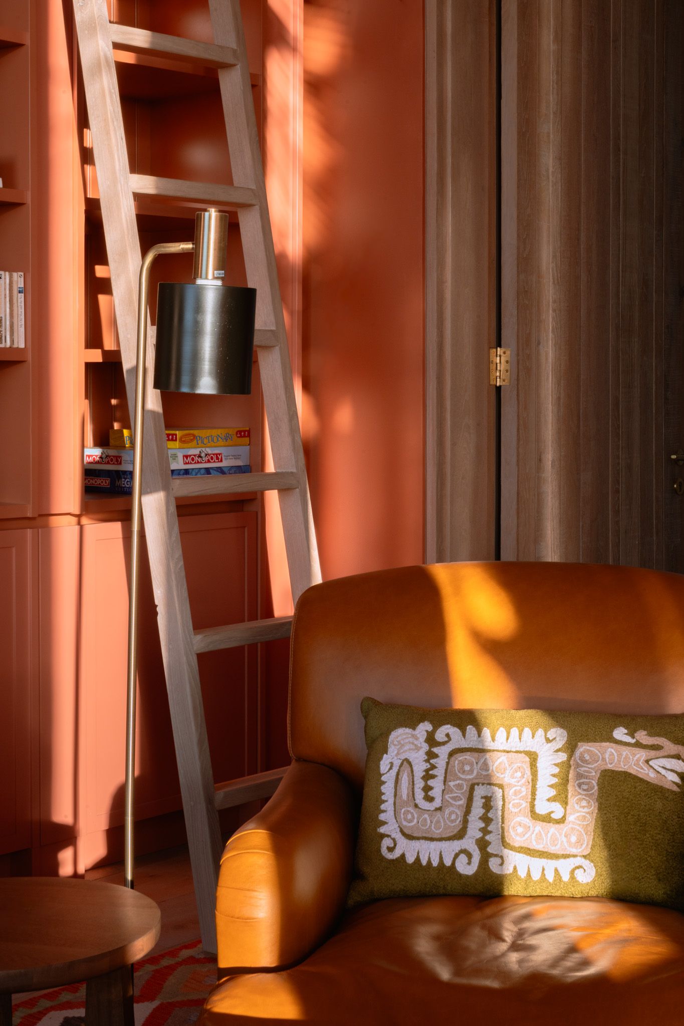 Cozy seating area with orange walls and decorative tribal-style cushions in warm lighting.