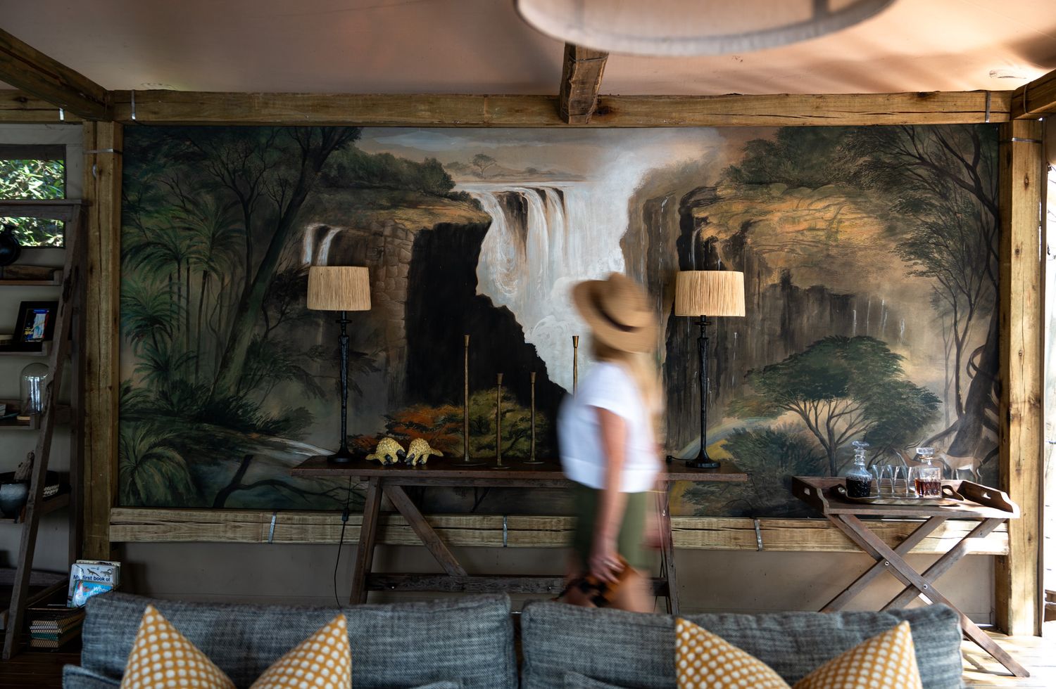 Rustic dining area with landscape murals and wooden beams on the ceiling.