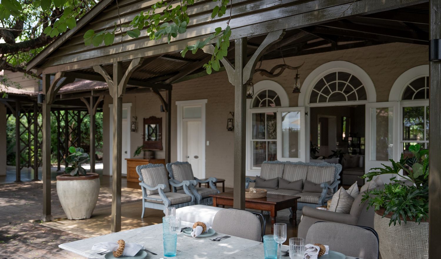 Covered veranda with comfortable outdoor seating and classic colonial-style architecture.