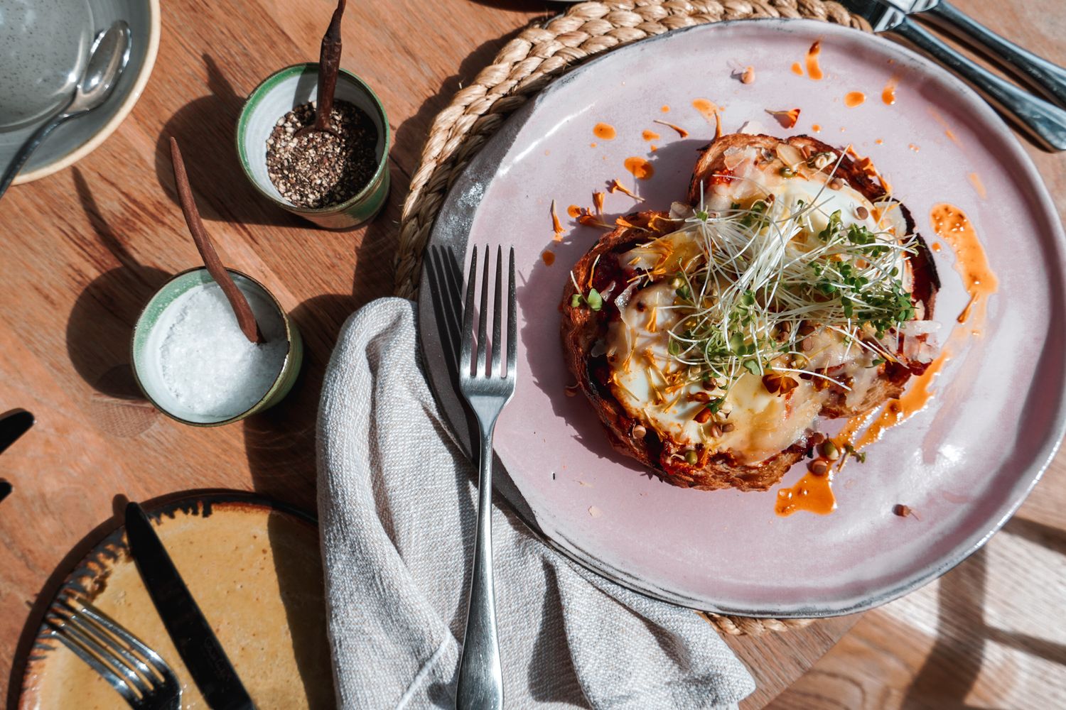 Close-up of artfully plated dishes with garnishes and sauces on white plates.