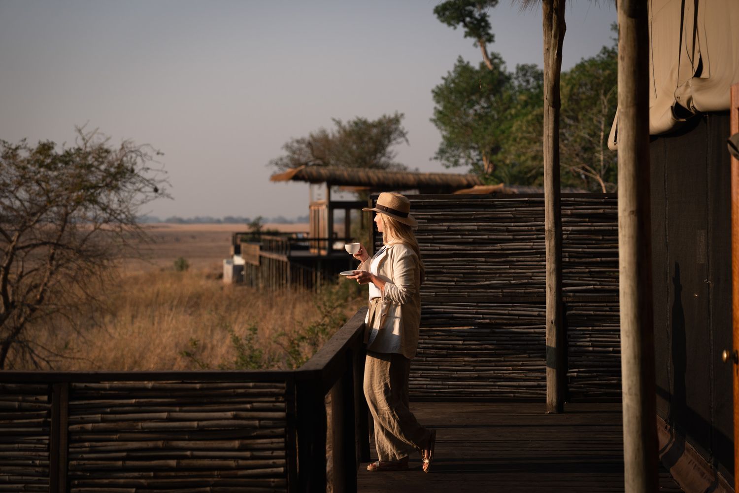 Safari lodge deck overlooking savanna landscape at sunset.