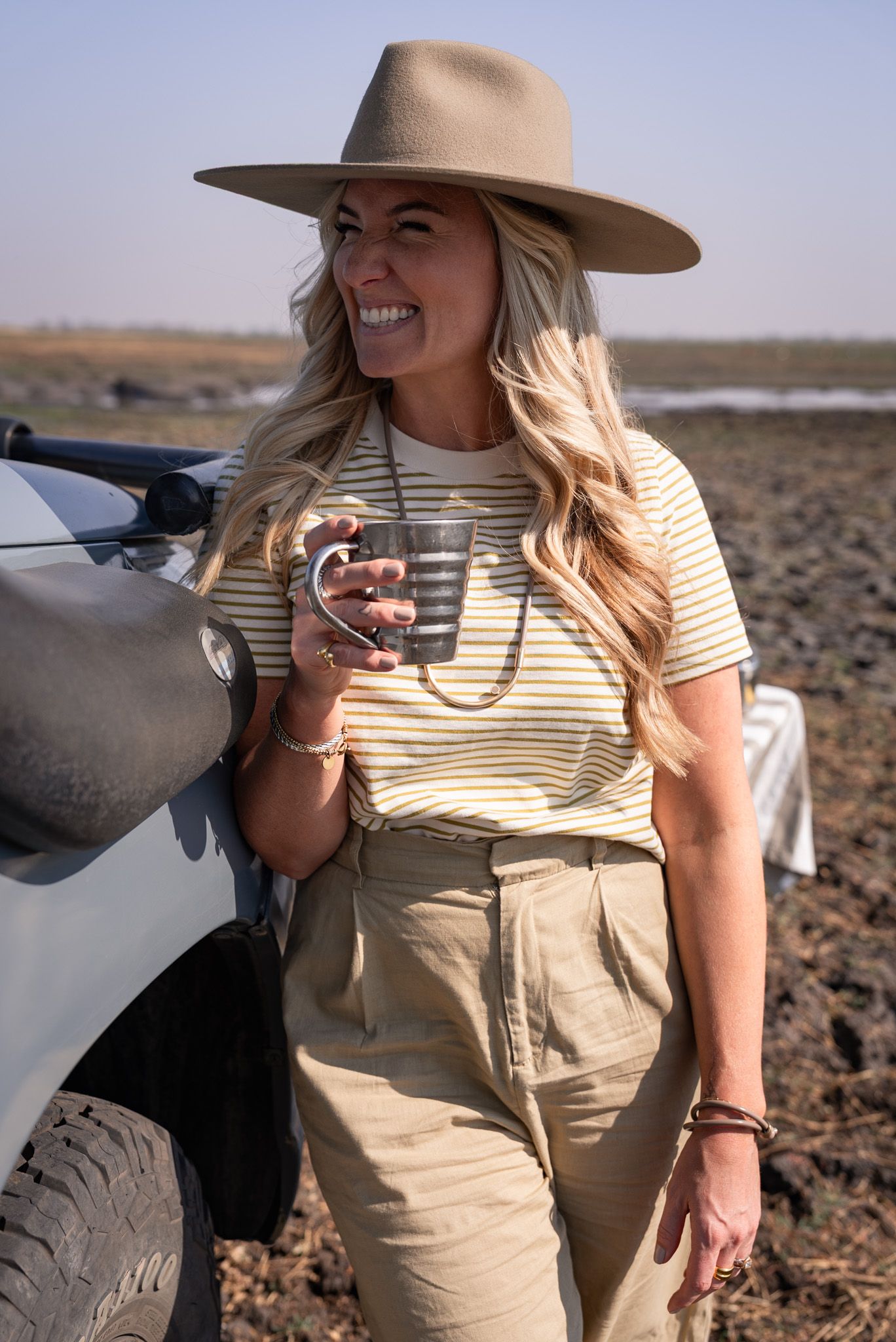 Safari-style adventure scene with khaki clothing and sun hat against rocky terrain.