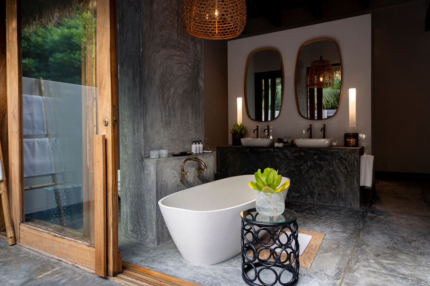 Luxury bathroom with freestanding white soaking tub, marble floors, dual vanity sinks, and floor-to-ceiling windows.