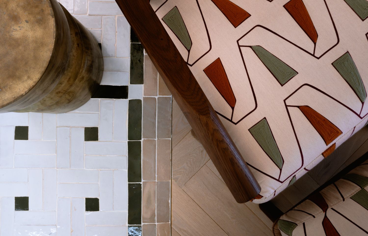Close-up detail of modern geometric patterned tiles and upholstery in muted earth tones.