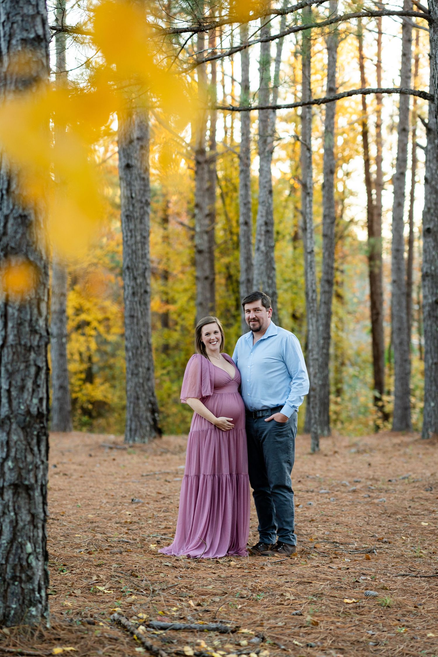 A romantic autumn photoshoot among tall pine trees with golden light.