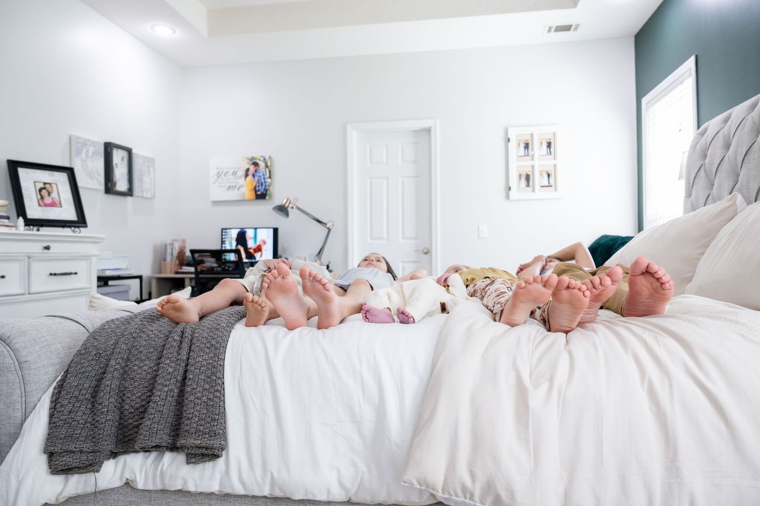 Modern in-home lifestyle photography session in a bright master bedroom.