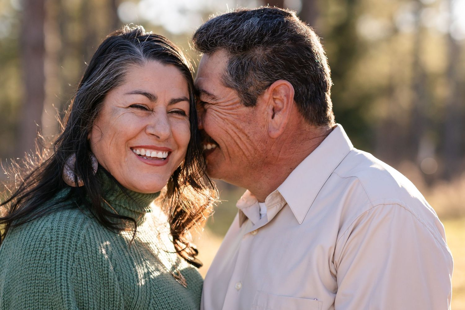 Romantic couple shares laughs and tender moments in golden hour lighting.