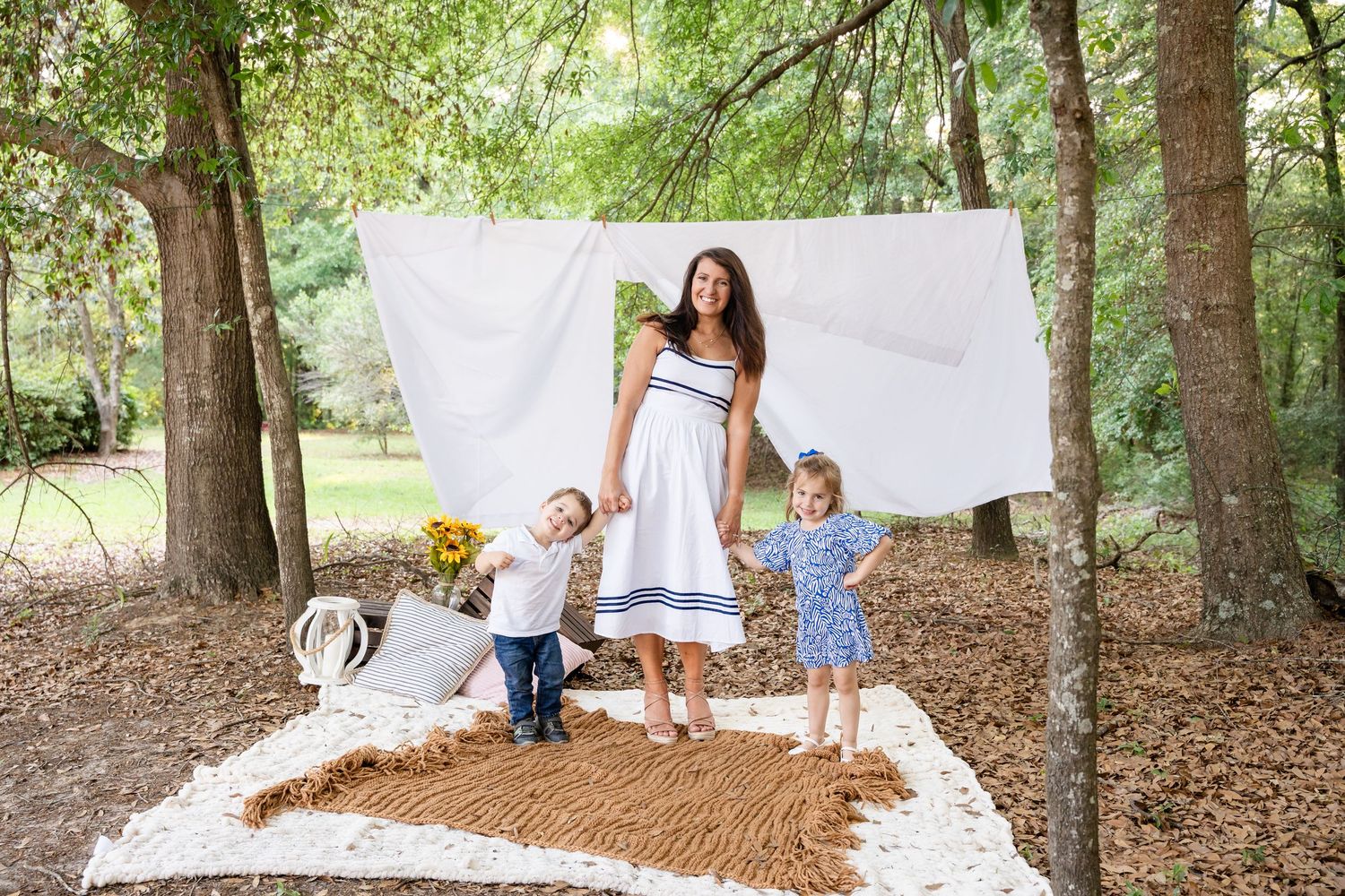 Family walking together during golden hour outdoor photoshoot in wooded area.