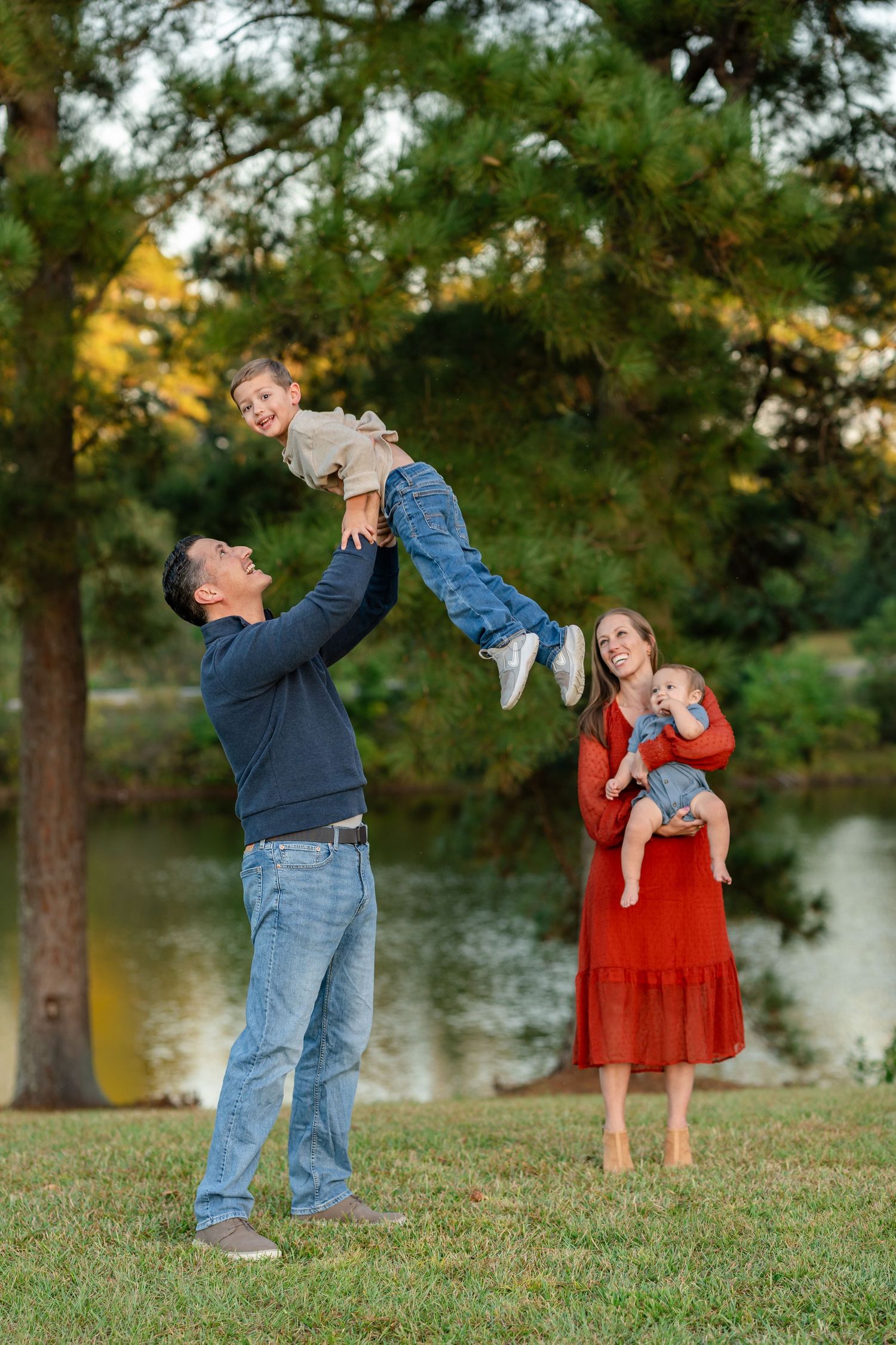 A series of four photos showing playful interactions in a park setting with trees and a lake in the background.