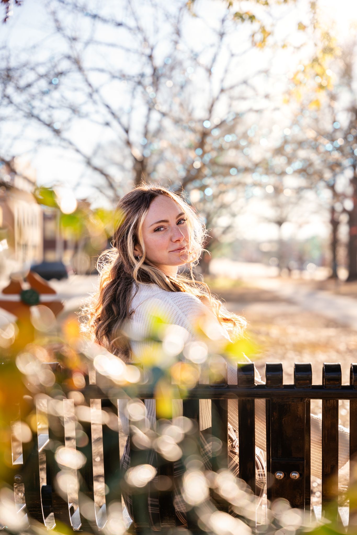 Backlit portrait series against wooden fence with bokeh effect from autumn sunlight.