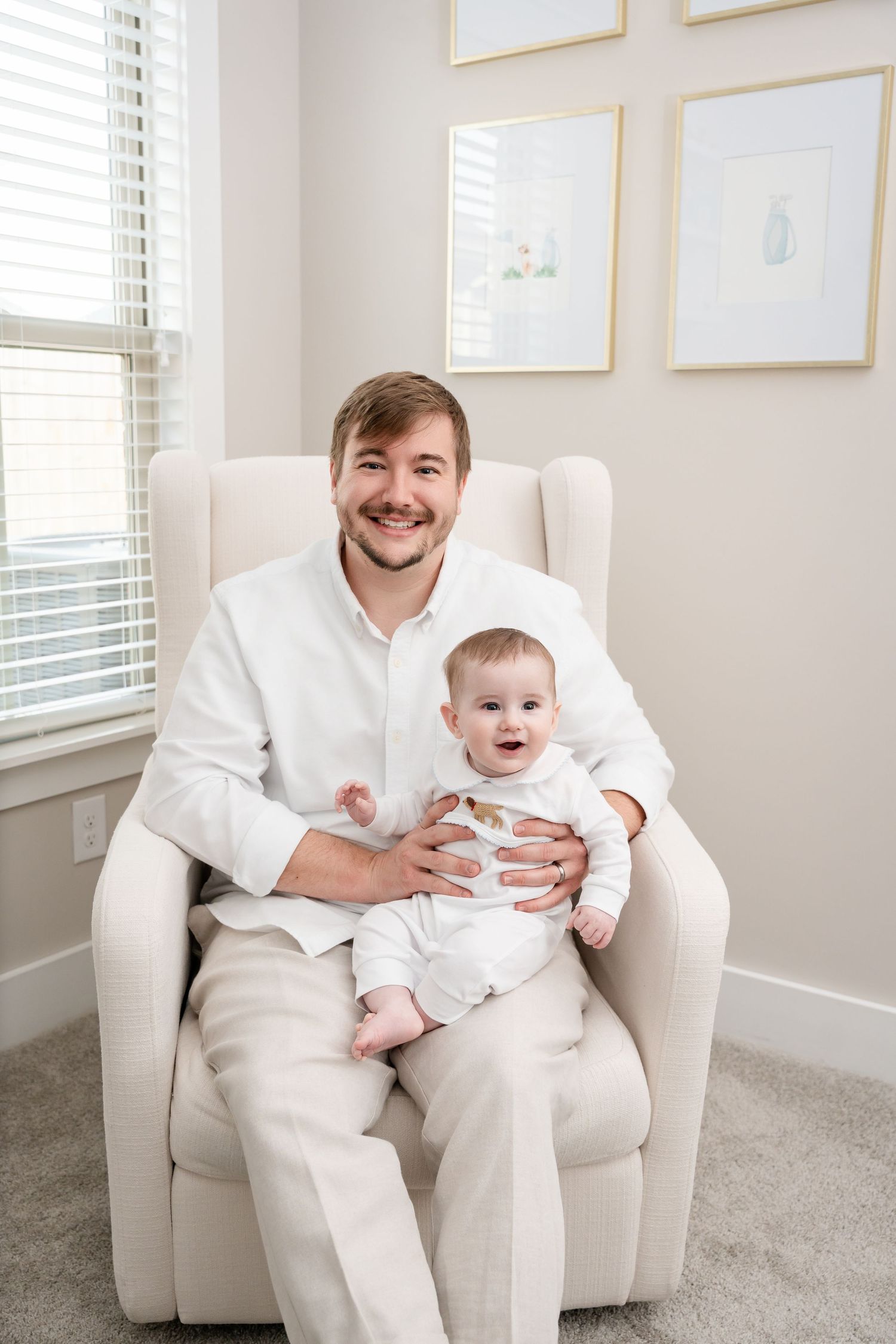 A relaxed portrait in a bright nursery with framed art on the wall.