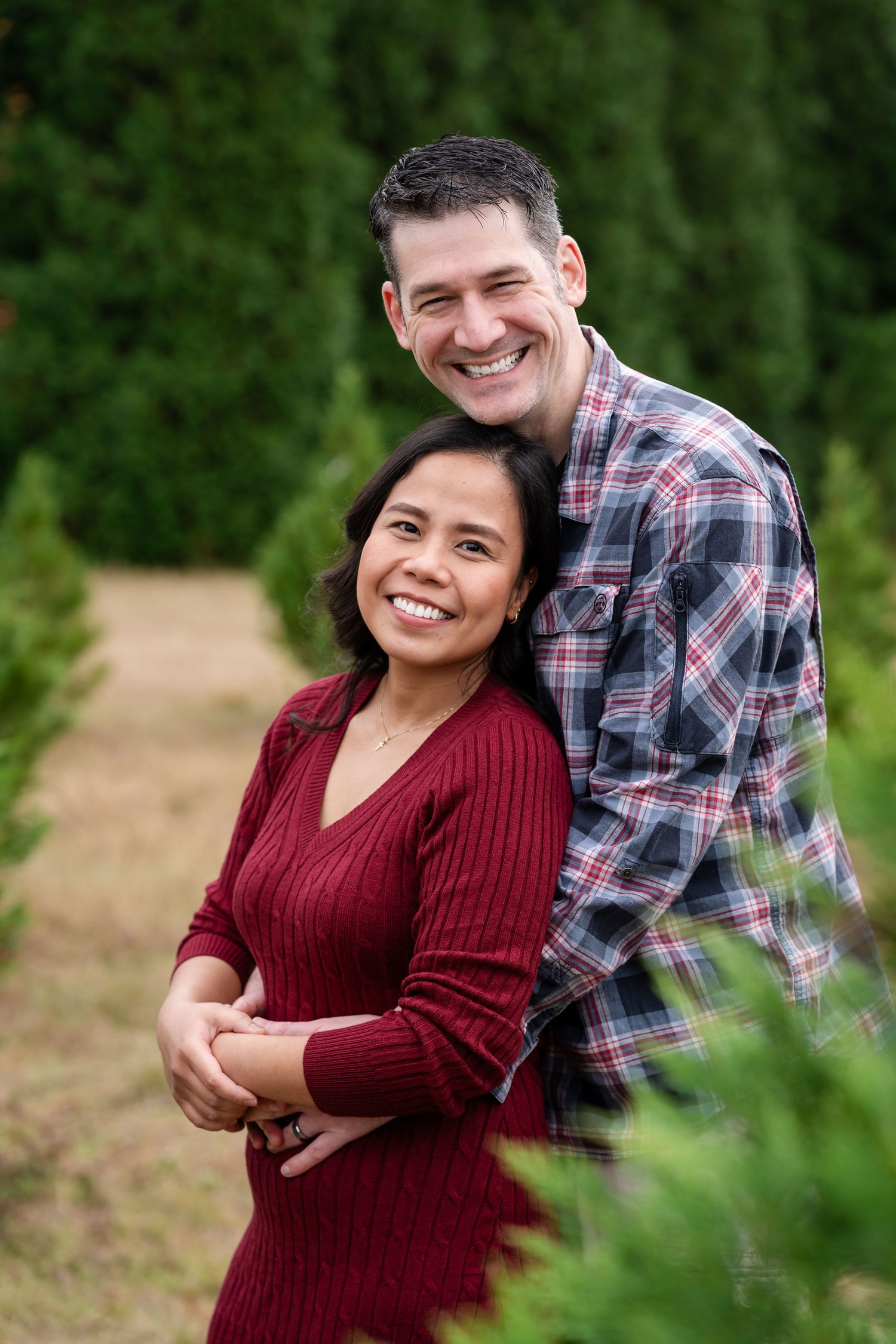 Couple sharing joyful moments together among evergreen trees.