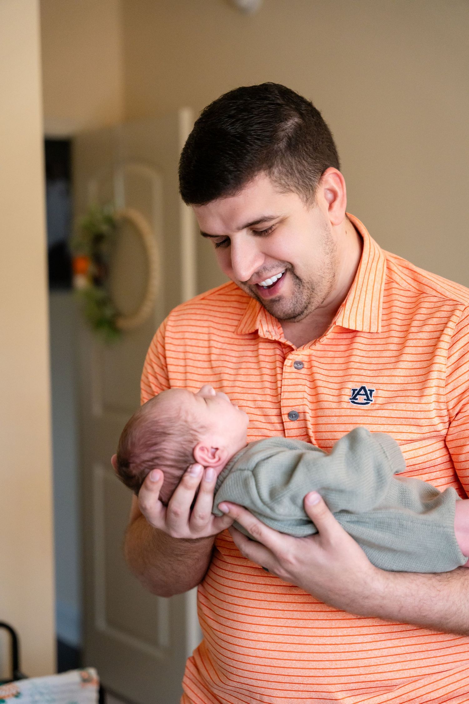 A tender moment between a caregiver and infant wearing a gray outfit.