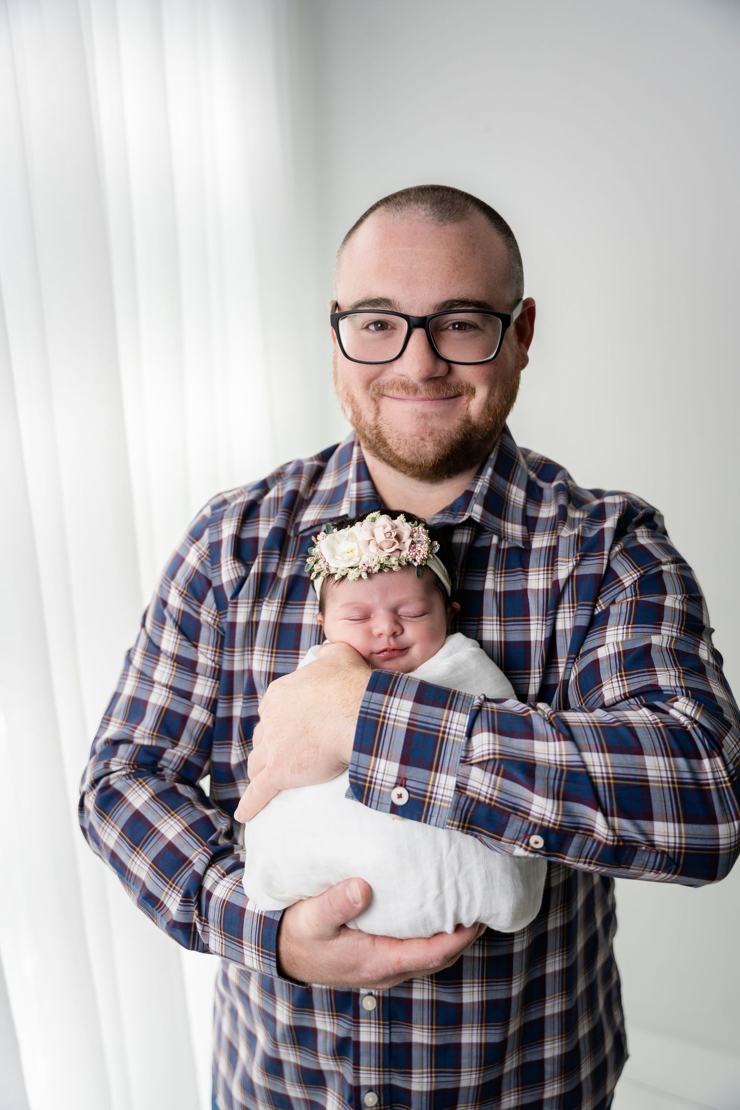 A series of photos showing someone in a plaid shirt holding and cuddling with a newborn baby.