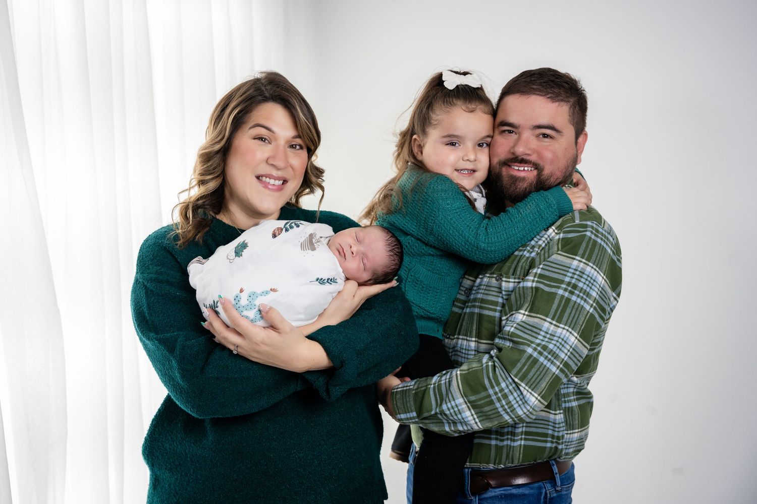 A lifestyle family portrait session against a bright white background.