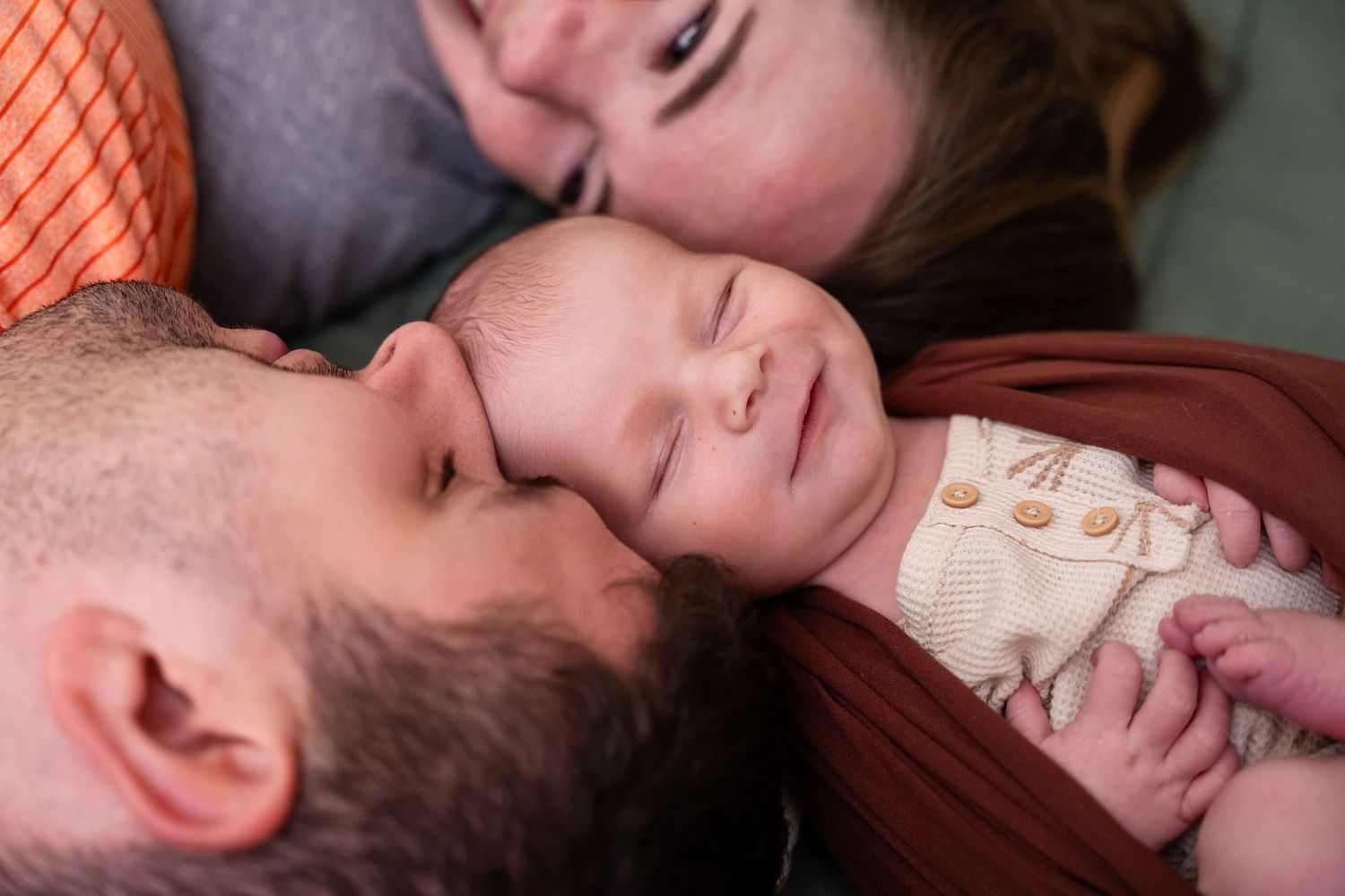 Close-up intimate portrait of sleeping baby in warm lighting.