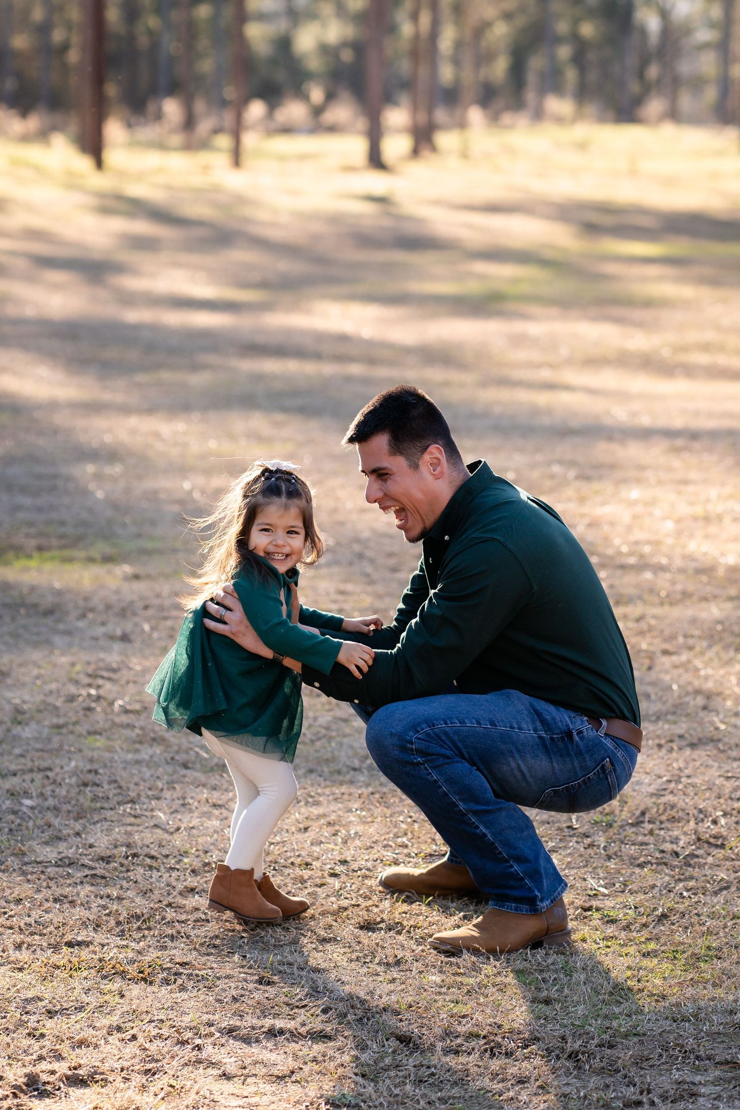 Sweet playful interaction between parent and child in an outdoor forest setting during golden hour.