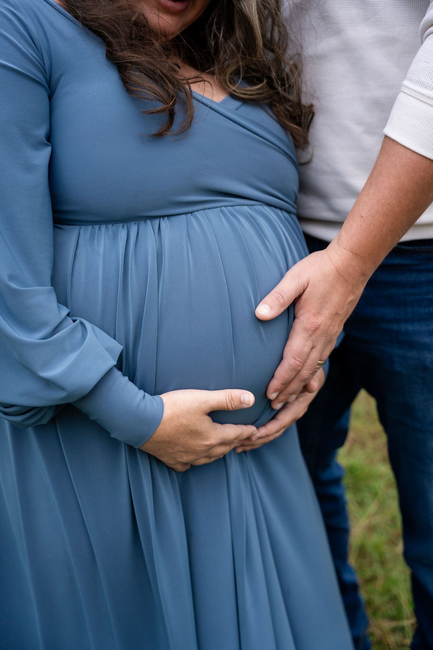 Close-up shots of maternity dress and hands cradling belly in dusty blue.