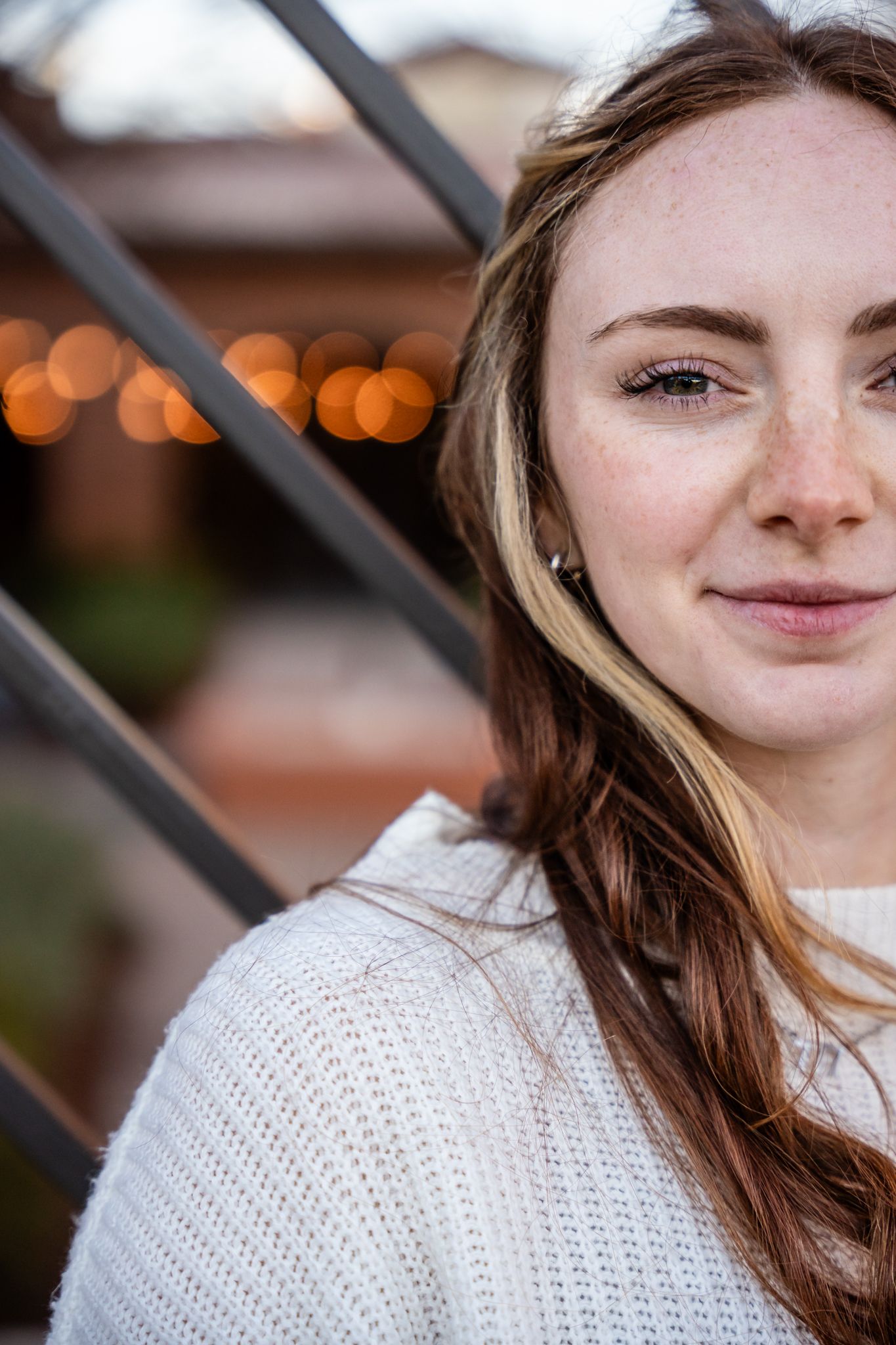 Close-up portraits with warm lighting showing cream knit sweater and natural makeup.